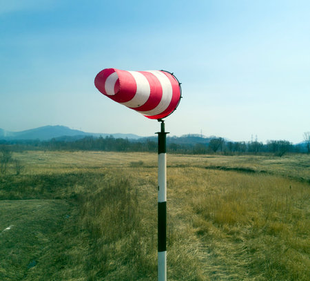 Red-white windsock indicating wind with blue sky