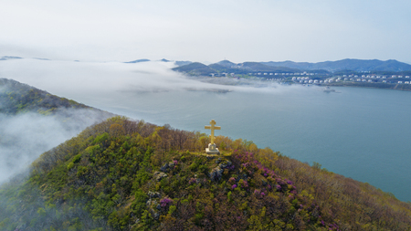 Nakhodka, Russia- May 4, 2017 Rocks , sea and Orthodox cross on the blue sky - Fox Island at the entrance to the port of Nakhodka Russiaの写真素材