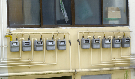 Pipes and gas-meter on wall house manyの写真素材