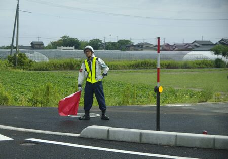 Japan road worker Stands on the side of the road with a flagのeditorial素材