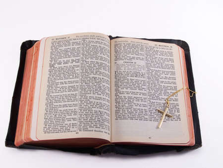 KJV Bible opened to Matthew 28, with gold cross on chain, isolated with の写真素材