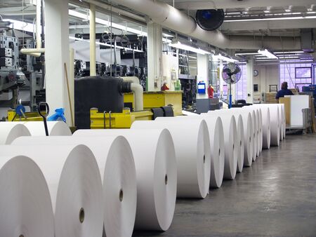 Rolls of paper waiting to be put on a printing press, visible in backgroundの写真素材