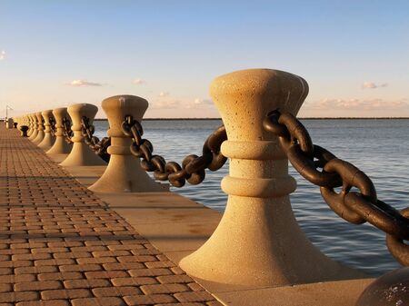 Bollards and chain along harbor frontの写真素材