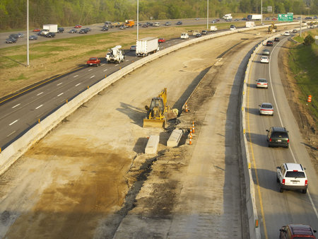 Traffic threading past a construction area in early morning light 