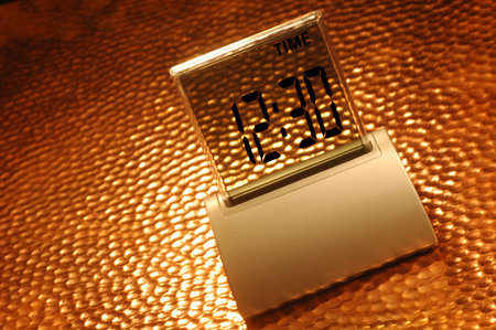 Small digital clock on a rippled surface under a golden light
