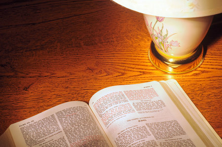 Lamp light shining on a Bible, metaphor for the Bible's light to the world