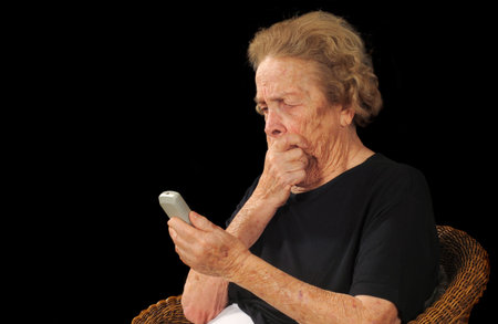 Elderly woman puzzled by an electronic device