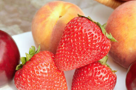 Closeup of luscious fruit medley: strawberries, peaches, plumsの写真素材