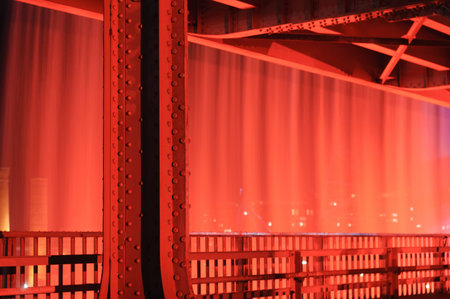 Illuminated man-made waterfall off a bridge seen from the interior of the bridge lower deckの写真素材