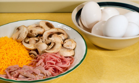 Ingredients for making omelets: eggs, cheese, ham, mushrooms