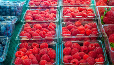 Assortment of fresh berries on display at a produce marketの写真素材