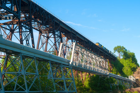 A freight train starting to cross a high trestle over a valley