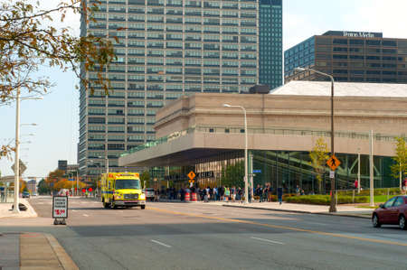 Cleveland, OH - October 5  An EMS ambulance races down the street in front of the recently opened convention center in Cleveland Ohio   A crowd can be seen queuing up for an exhibit in the convention center のeditorial素材
