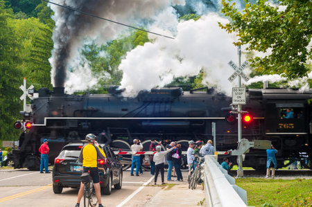 BRECKSVILLE, OH - SEPTEMBER 14 2014: Spectators watch as a steam lodcomotive passes a grade crossing...