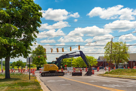 TWINSBURG, OH - JULY 10, 2016: A parked backhoe blocks access to an intersection in which a new...