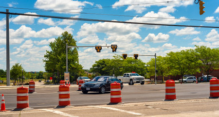 TWINSBURG, OH - JULY 10, 2016: Vehicles enter a partially closed intersection in which a new...