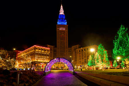 CLEVELAND, OH - DECEMBER 30, 2016: Cleveland's Terminal Tower, lit up for Christmas, stands over brightly lit holiday displays on Public Square.のeditorial素材