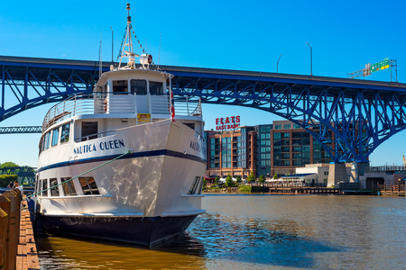CLEVLEAND, OH - MAY 25, 2018: The Nautica Queen, a popular ship for dinner cruises on the Cuyaghoa River and Lake Erie, rests at her dock before the Main Avenue Bridge and Flats East Bank entertainment area.のeditorial素材