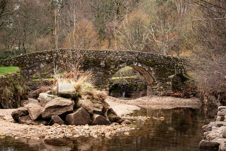 Medieval stone bridge over river and trees in the backgroundの写真素材