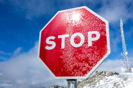 Stop sign in the snow with a blue skyの写真素材