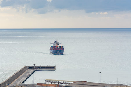 Malaga, Spain; 12/20/2019: Container ship fully loaded in the sea approaching the port
