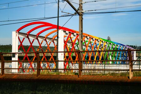 Bridge decorated with colored arches to access the train tracksの写真素材