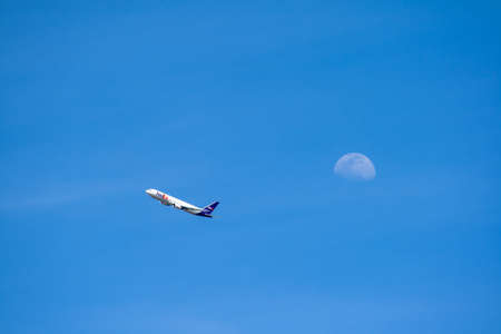 San Sebastian de los Reyes, Madrid, Spain; 02/05/2020: White plane with blue details of the company FedEx Corporation flying with a blue sky and moon in the backgroundのeditorial素材