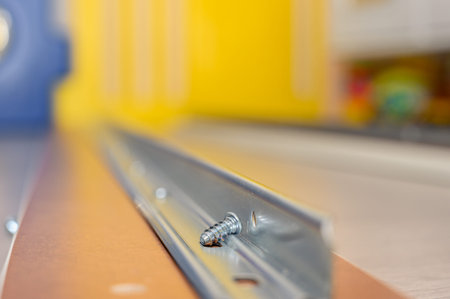 Macro photography of a screw deposited on the rail in which it will be screwed
