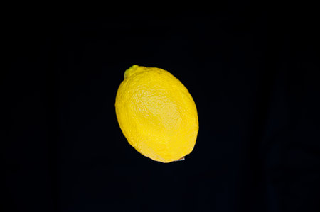 Whole piece of lemon isolated on a black backgroundの写真素材