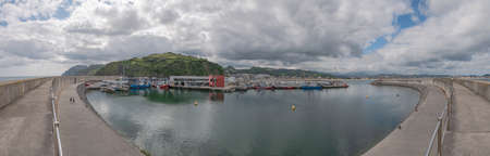 Laredo, Cantabria, Spain; 08-17-2021: Overview of the fishing port of Laredo with the boats docked next to the San MartÃ­n fishermen's association and the marina and the village in the backgroundのeditorial素材