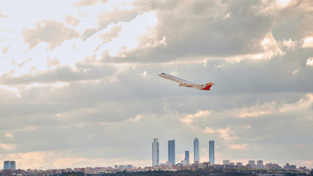 Madrid, Spain; 09-25-2021: Mitsubishi Crj -1000 aircraft of the Iberia Regional airline taking off from Madrid airport leaving behind a panorama of its famous office towersのeditorial素材