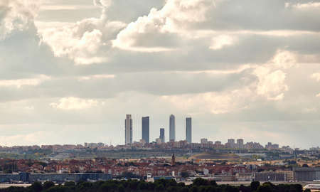 Madrid, Spain; 09-25-2021: Panoramic view of the famous five office towers in Madrid with houses from the eastern neighborhoods of Madrid in front and a cloudy skyのeditorial素材