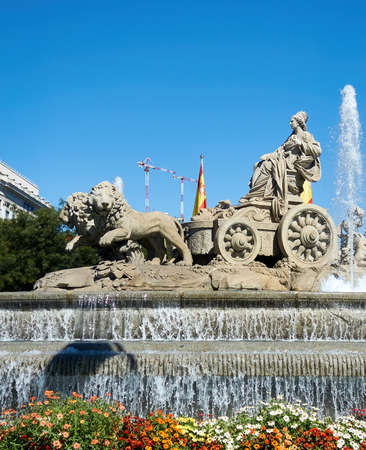 Madrid, Spain; 09-21-2021: Fountain of the Greek goddess Cibeles with a sculpture of the same rise in a chariot drawn by lions and with some cranes behind it, representative of real estate speculationのeditorial素材