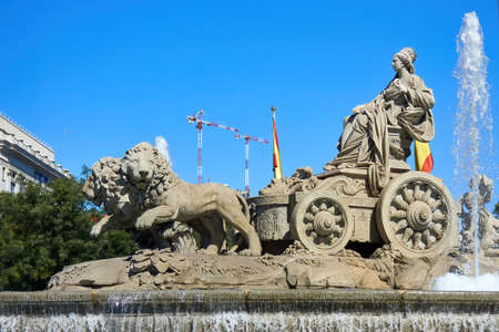 Madrid, Spain; 09-21-2021: Fountain of the Greek goddess Cibeles with a sculpture of the same rise in a chariot drawn by lions and with some cranes behind it, representative of real estate speculationのeditorial素材
