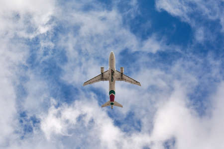 Madrid, Spain; 09-25-2021: Airbus A319 of the Alitalia airline seen with a low angle view just after take off in cloudy blue skyのeditorial素材