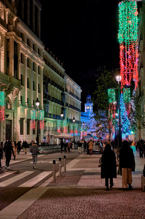 Madrid, Spain; 12-01-2021: Nice winter view of the Puerta del Sol tower from Alcala street with people walking with christmas decoration onのeditorial素材