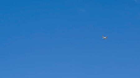 Small recreational plane, ideal for flight practice flying over a blue sky on a clear dayの写真素材