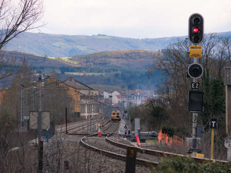 Monforte de Lemos, Lugo, Spain; 03-21-2022; Illuminated signal at the entrance to Monforte station indicating red (stop) during the electrification works and a workshop train working on the trackのeditorial素材
