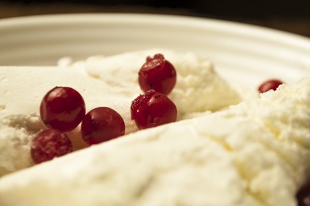 Ice cream in a corrugated white dish with red viburnum berriesの写真素材