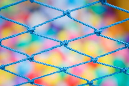 Rope fence with Multi-colored balls on backgroundの写真素材