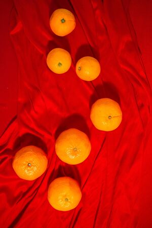 Oranges and gold on red fabric, Chinese New Yearの写真素材