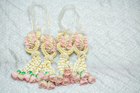 Beautiful Thai-style jasmine garland on a silver cloth background with an ancient Thai pattern.の写真素材