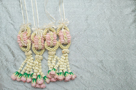 Beautiful Thai-style jasmine garland on a silver cloth background with an ancient Thai pattern.の写真素材