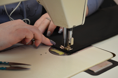 seamstress sews fabric for uniformの写真素材