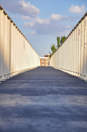Textured abstract pattern with sunset shadows on an empty pedestrian walkway bridge in Madrid.Facade with windows in the end background.の写真素材