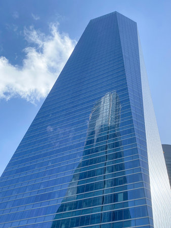 low angle view of modern skyscraper. Second building is reflected in the glass facadeの写真素材