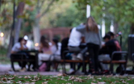 blurred on purpose group people man girls friends enjoying and celebrating outdoor park in autumn fallの写真素材