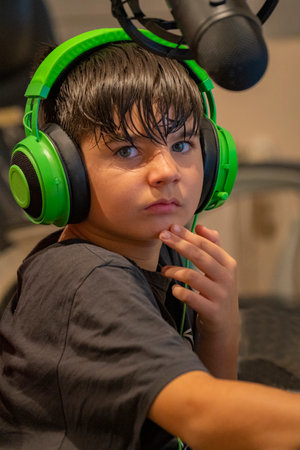 Child ready and equipped to start gaming and live streaming at home in his room.の写真素材
