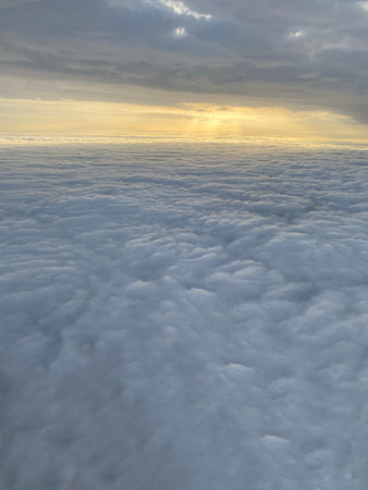 Beautiful golden sun rays background with sunset shinning between a layer of clouds viewed from...
