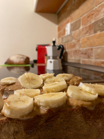 Healthy breakfast ready to eat with fitness bread, peanut butter, nuts and bananas homemade in the kitchenの写真素材